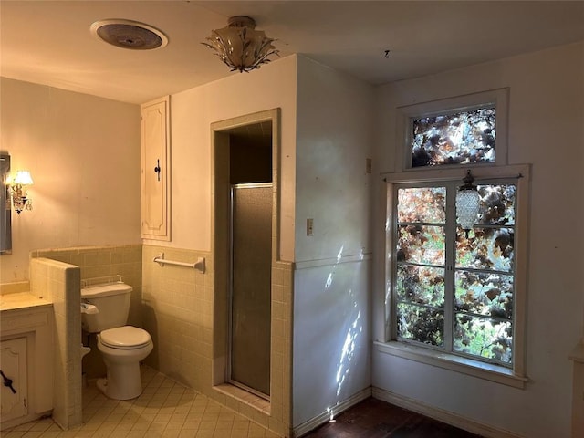 1006 Gilmore St, Taylor, TX 76574 - full bath with vanity, a stall shower, tile walls, plenty of natural light, and wainscoting