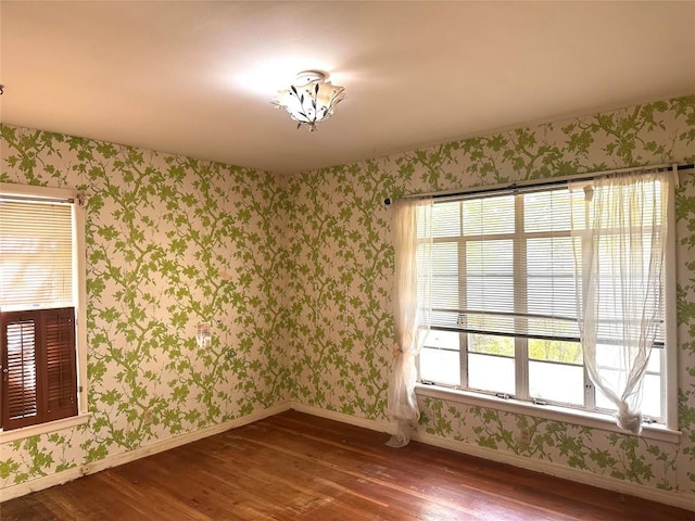 1006 Gilmore St, Taylor, TX 76574 - unfurnished room featuring wallpapered walls, hardwood / wood-style floors, and plenty of natural light