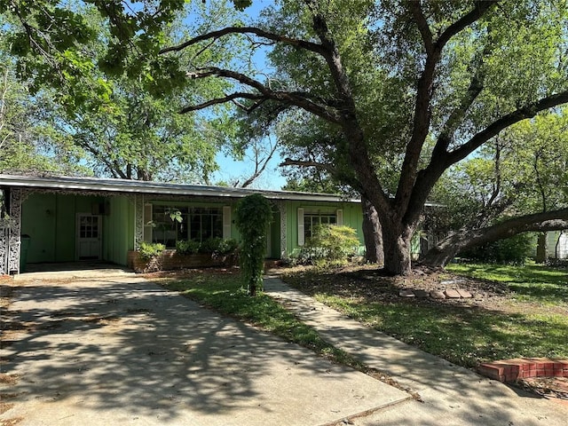 1006 Gilmore St, Taylor, TX 76574 - ranch-style house with driveway, board and batten siding, and a carport