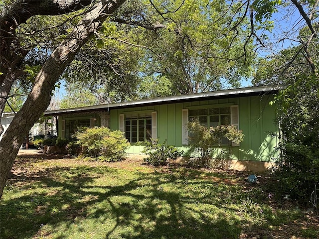 1006 Gilmore St, Taylor, TX 76574 - view of home's exterior featuring board and batten siding and a lawn