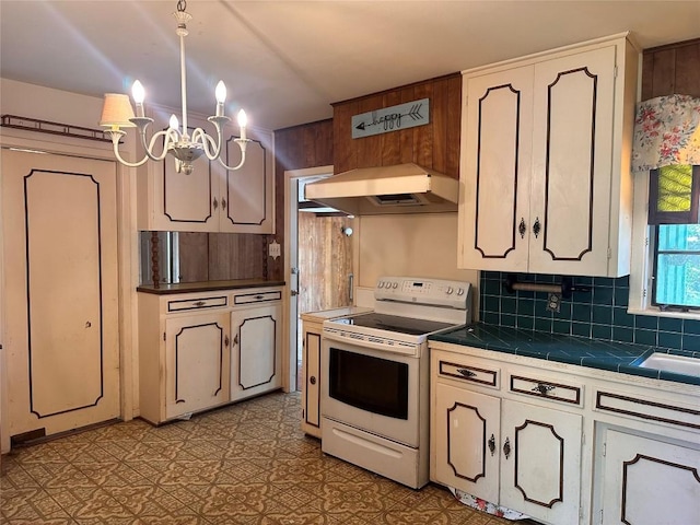 1006 Gilmore St, Taylor, TX 76574 - kitchen featuring white electric stove, premium range hood, tile countertops, a chandelier, and backsplash