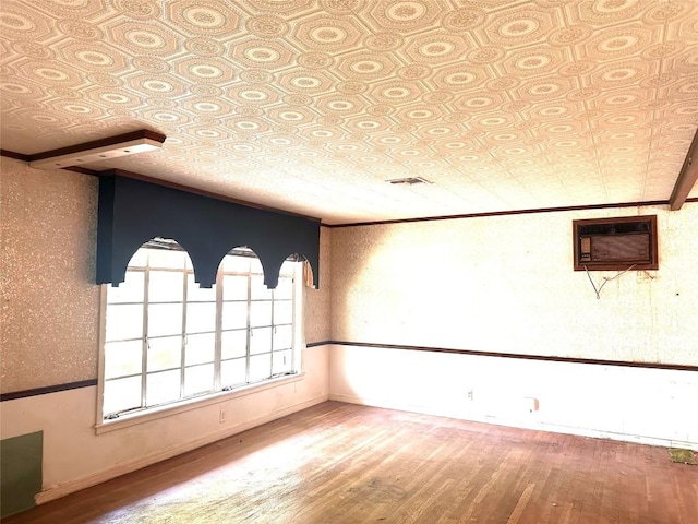 1006 Gilmore St, Taylor, TX 76574 - spare room with wood finished floors, an ornate ceiling, and an AC wall unit