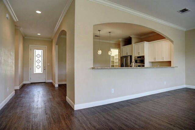 159 Alele Dr, Bastrop, TX 78602 - foyer entrance featuring dark wood-style flooring, arched walkways, recessed lighting, and crown molding