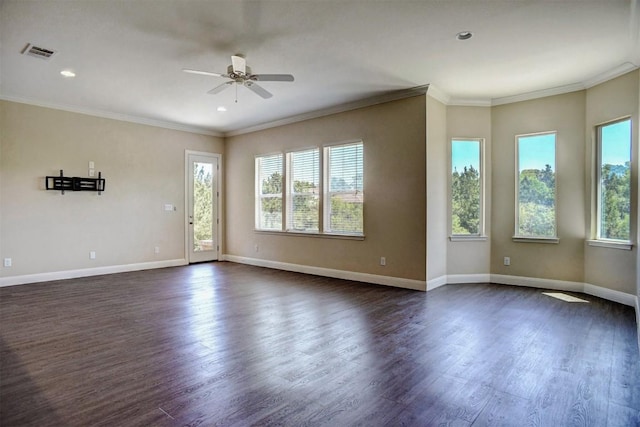 spare room with a wealth of natural light, a ceiling fan, dark wood finished floors, and visible vents