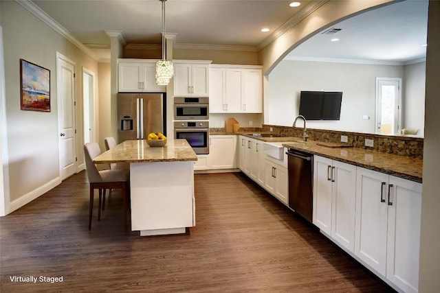 159 Alele Dr, Bastrop, TX 78602 - kitchen featuring appliances with stainless steel finishes, dark wood finished floors, white cabinetry, stone countertops, and ornamental molding