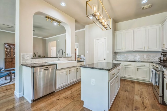 kitchen with arched walkways, backsplash, visible vents, and stainless steel appliances