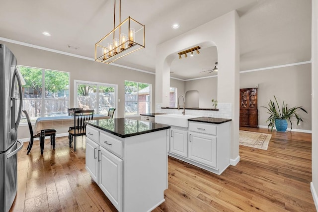 kitchen featuring crown molding, ceiling fan, a sink, and stainless steel refrigerator with ice dispenser