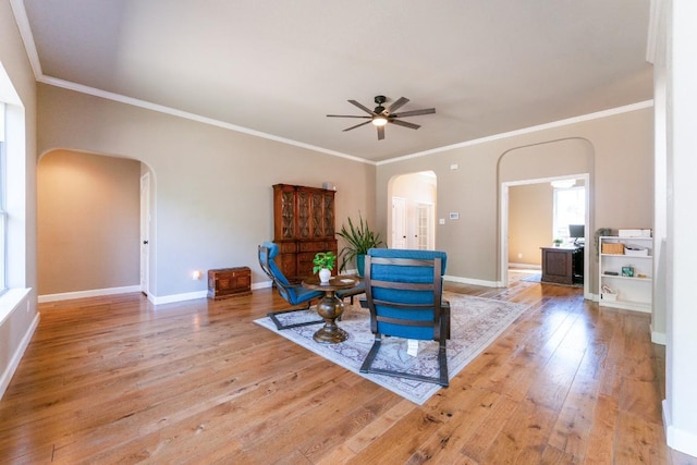 sitting room with ceiling fan, arched walkways, hardwood / wood-style floors, and baseboards