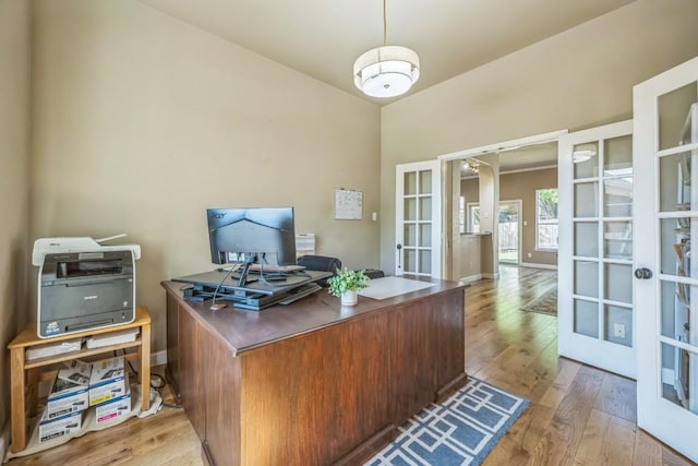 office space with french doors, baseboards, and hardwood / wood-style flooring