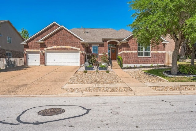 ranch-style house with a garage, brick siding, driveway, and fence