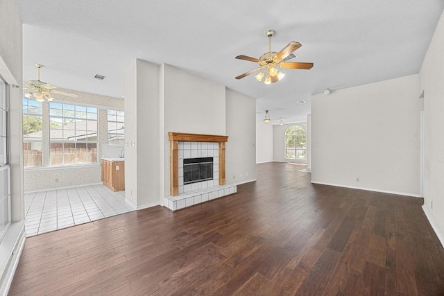 unfurnished living room featuring a fireplace, hardwood / wood-style floors, and a ceiling fan