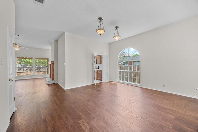 unfurnished room featuring visible vents, baseboards, a ceiling fan, and dark wood-style floors