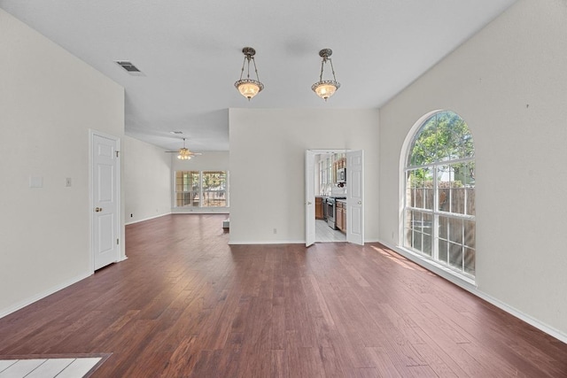 unfurnished living room with baseboards, dark wood-style floors, and visible vents
