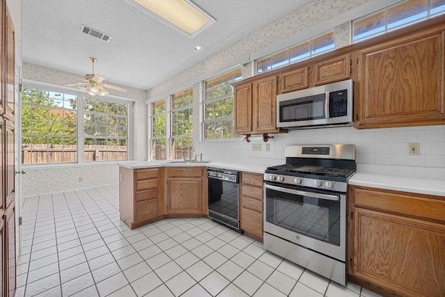kitchen featuring brown cabinetry, light countertops, visible vents, and stainless steel appliances