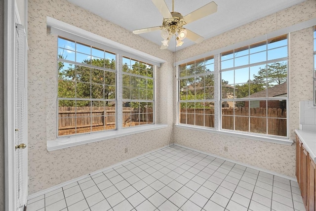 unfurnished sunroom with wallpapered walls and plenty of natural light