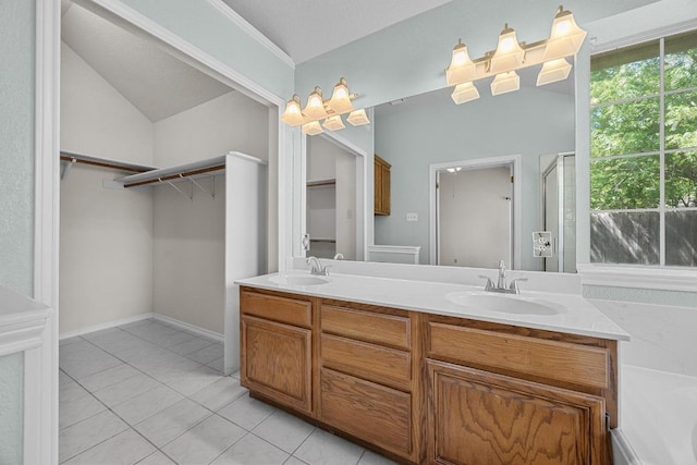 bathroom featuring double vanity, a sink, tile patterned flooring, and a spacious closet