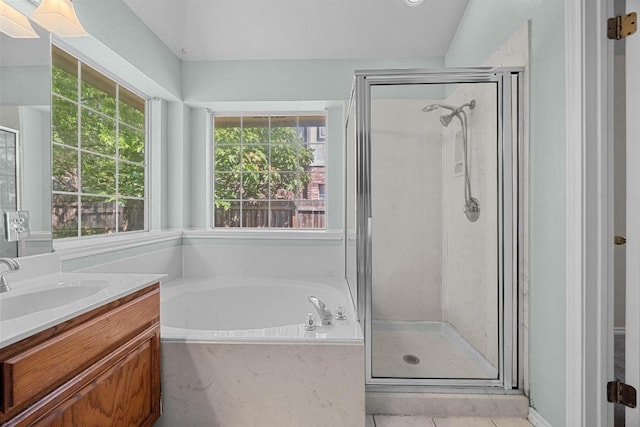bathroom with a bath, a wealth of natural light, a stall shower, and vanity