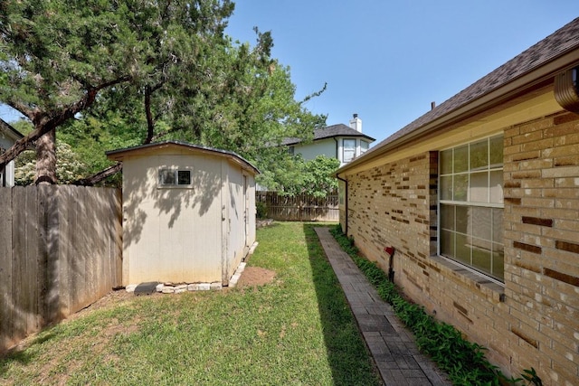 view of yard featuring a storage shed, a fenced backyard, and an outdoor structure