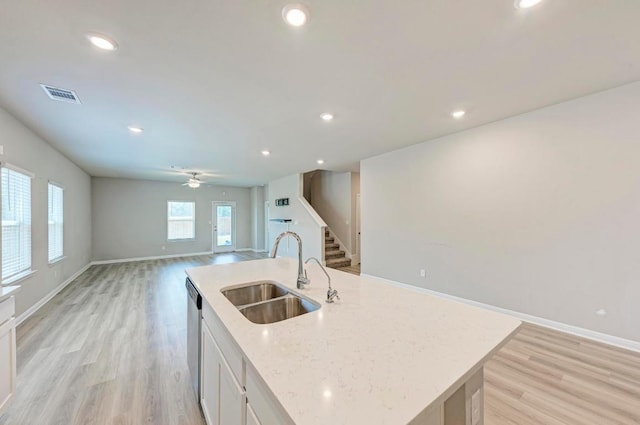 1528 Longhorn Ranch Dr, Leander, TX 78641 - kitchen featuring stainless steel dishwasher, open floor plan, light wood-style flooring, white cabinetry, and recessed lighting