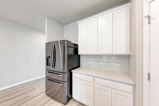 1528 Longhorn Ranch Dr, Leander, TX 78641 - kitchen with stainless steel refrigerator with ice dispenser, backsplash, white cabinets, and light wood-style flooring