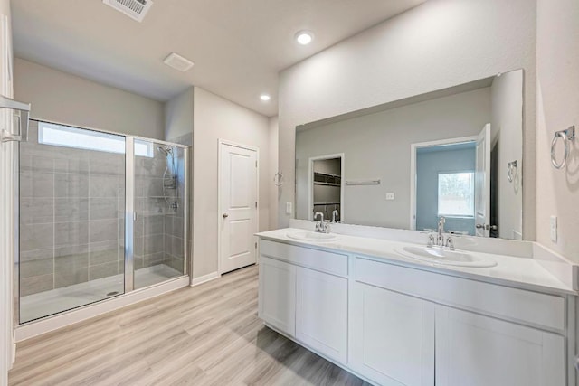 1528 Longhorn Ranch Dr, Leander, TX 78641 - full bathroom with healthy amount of natural light, a shower stall, double vanity, wood finished floors, and recessed lighting