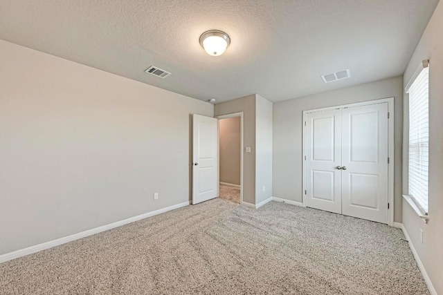 1528 Longhorn Ranch Dr, Leander, TX 78641 - unfurnished bedroom featuring carpet, a textured ceiling, and a closet