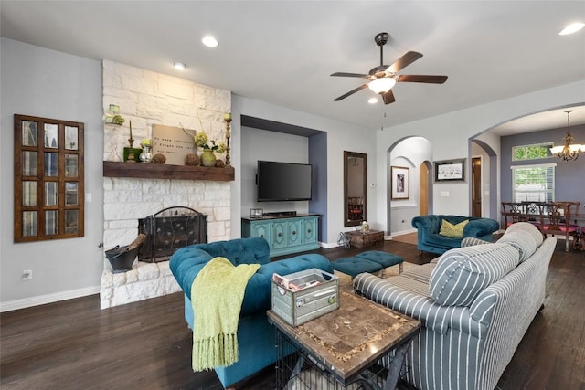 109 Lombardia Dr, Lakeway, TX 78734 - living area featuring arched walkways, wood finished floors, a ceiling fan, a stone fireplace, and a chandelier