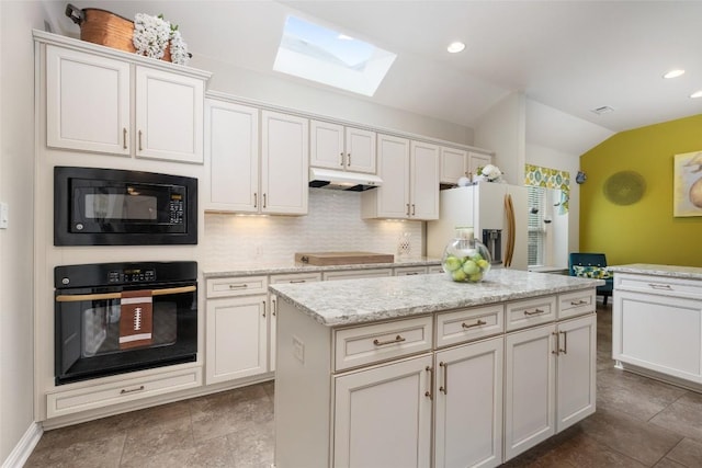 109 Lombardia Dr, Lakeway, TX 78734 - kitchen with black appliances, lofted ceiling, a skylight, under cabinet range hood, and backsplash