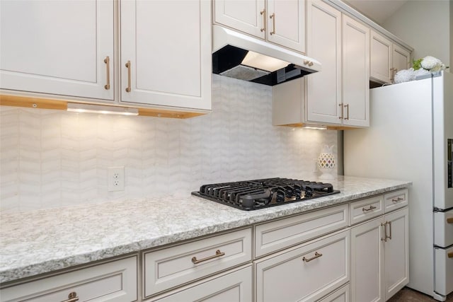 109 Lombardia Dr, Lakeway, TX 78734 - kitchen with under cabinet range hood, black gas stovetop, backsplash, and white cabinetry