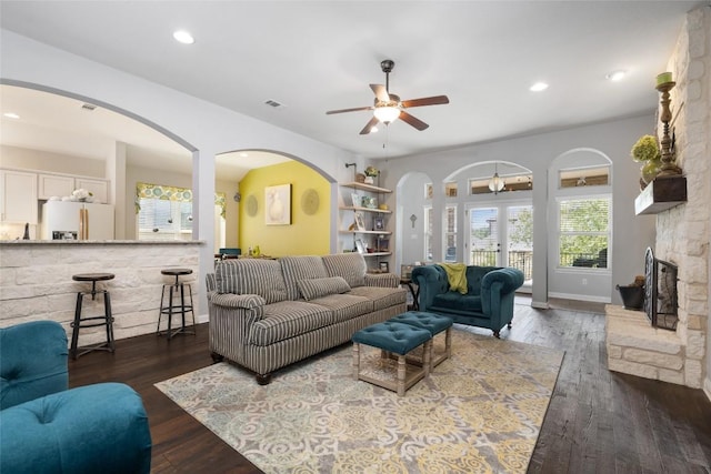 109 Lombardia Dr, Lakeway, TX 78734 - living room featuring ceiling fan, recessed lighting, wood finished floors, arched walkways, and a stone fireplace