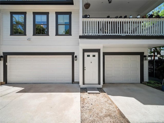 view of front of house with a garage, driveway, and a balcony