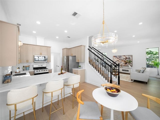 kitchen featuring a peninsula, light countertops, a sink, and appliances with stainless steel finishes