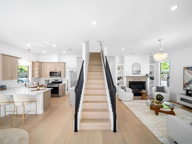 stairs featuring wood finished floors, a glass covered fireplace, and recessed lighting