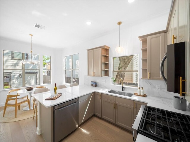 kitchen featuring a wealth of natural light, a sink, open shelves, and appliances with stainless steel finishes