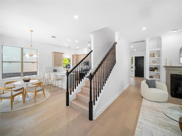 stairs with a glass covered fireplace, visible vents, recessed lighting, wood finished floors, and baseboards