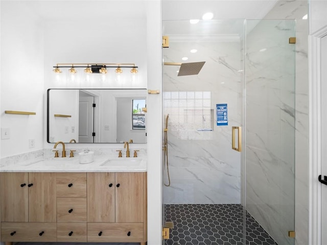 bathroom with a marble finish shower, double vanity, and a sink