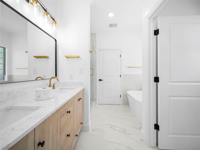 bathroom featuring a freestanding tub, double vanity, visible vents, marble finish floor, and a sink