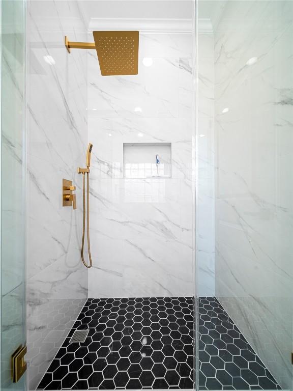 full bath with ornamental molding and a marble finish shower