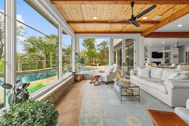 sunroom / solarium featuring wood ceiling, beamed ceiling, wood-type flooring, and visible vents