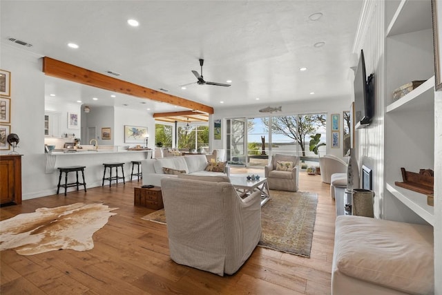 living room with visible vents, ceiling fan, beam ceiling, recessed lighting, and light wood finished floors