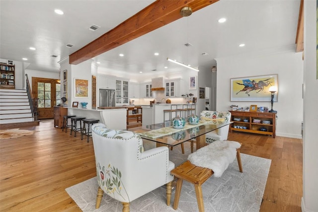 dining space with light wood-type flooring, recessed lighting, visible vents, and stairway