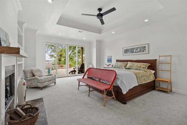 carpeted bedroom featuring a premium fireplace, access to outside, a raised ceiling, and ornamental molding
