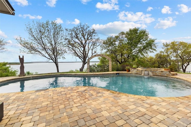 pool featuring a water view and a patio area