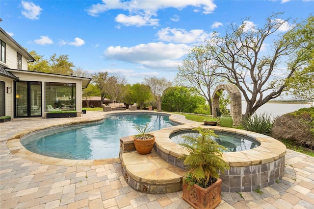 outdoor pool with a patio area and an in ground hot tub