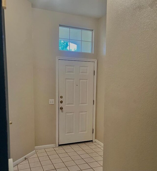 506 Clearcreek Dr, Leander, TX 78641 - foyer with light tile patterned floors, baseboards, and a textured wall