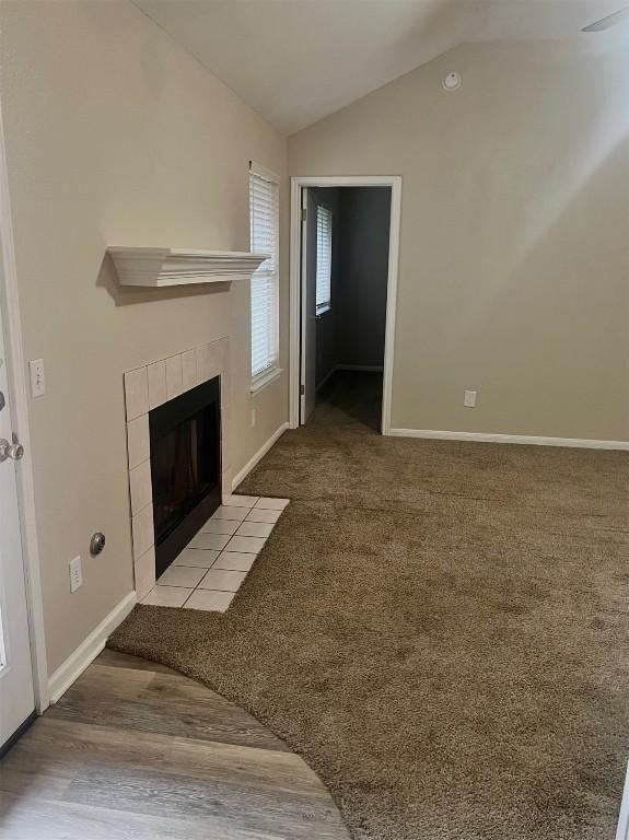 506 Clearcreek Dr, Leander, TX 78641 - unfurnished living room with vaulted ceiling, a tiled fireplace, and baseboards