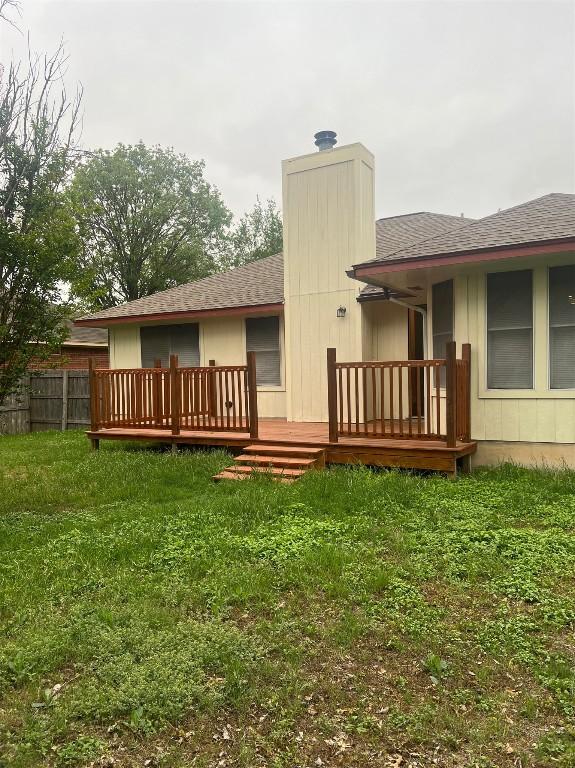 506 Clearcreek Dr, Leander, TX 78641 - rear view of property featuring a wooden deck, a shingled roof, and a chimney