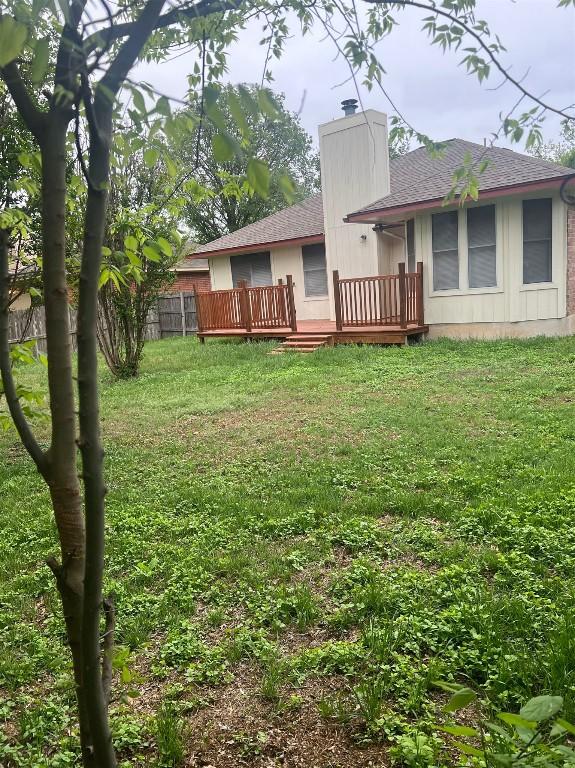 506 Clearcreek Dr, Leander, TX 78641 - rear view of property featuring a chimney, a deck, a shingled roof, and a yard