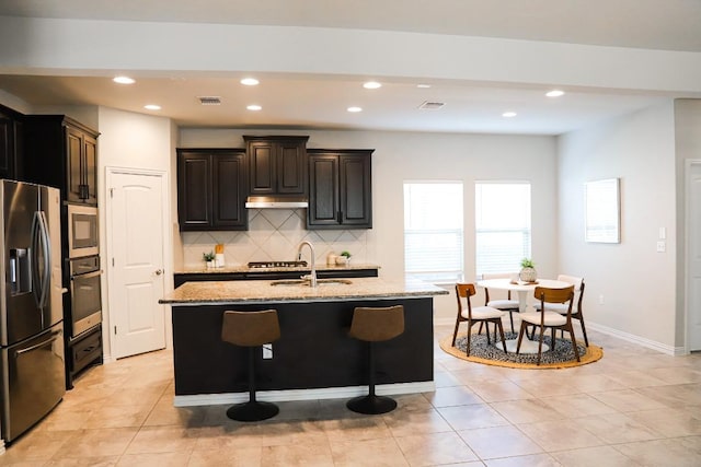 8801 Mina Dr, Austin, TX 78747 - kitchen featuring stainless steel appliances, a sink, decorative backsplash, light stone counters, and recessed lighting