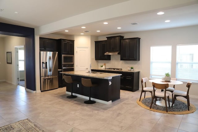 8801 Mina Dr, Austin, TX 78747 - kitchen featuring appliances with stainless steel finishes, decorative backsplash, recessed lighting, under cabinet range hood, and light stone countertops